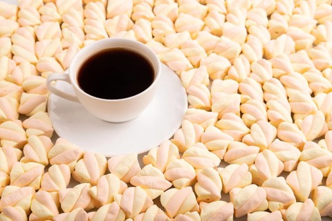 Cup of coffee on Orange and pink marshmallow background, side view, copy space, minimalism