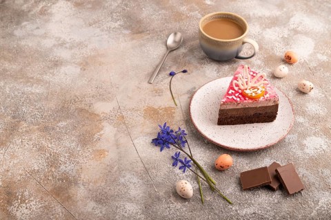 Chocolate cake on brown concrete background, cup of coffee, side view, copy space
