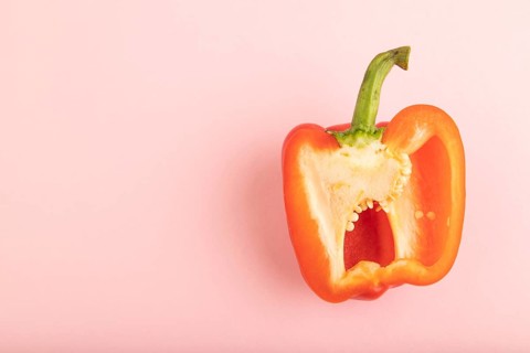 Red Cutted pepper on pink pastel background. Top view, flat lay, copy space. Tropical, healthy