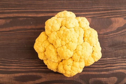 Yellow Cauliflower on brown wooden background. Top view, close up, flat lay. healthy food,