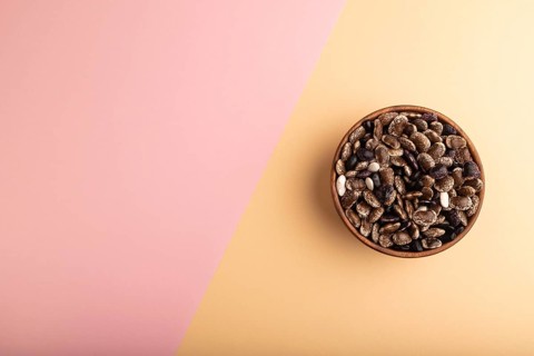 Wooden bowl with Kidney beans on pink and orange pastel paper background, top view, flat lay, copy