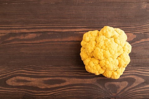 Yellow Cauliflower on brown wooden background. Top view, copy space, flat lay. healthy food,