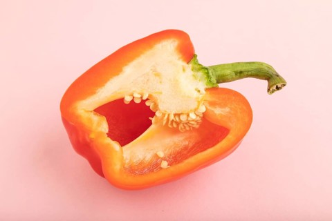 Red Cutted pepper on pink pastel background. Side view, copy space. Tropical, healthy food,