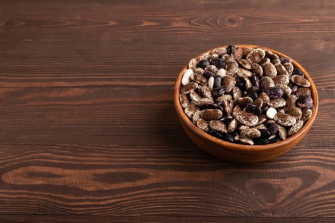 Wooden bowl with Kidney beans on brown wooden background, side view, copy space, minimalism