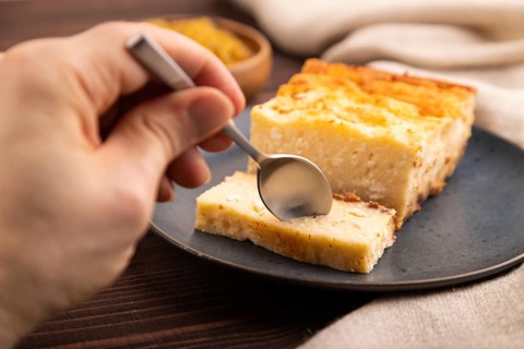 ?ottage cheese ?asserole, Curd cake, with dried apricots and raisins with hand on brown wooden