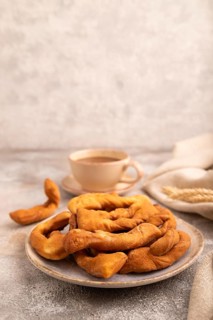 Crunchy biscuit Brushwood cookies sprinkled with powdered sugar on brown concrete background and