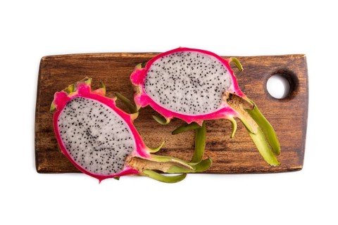 Ripe Pitaya on cutting board isolated on white background, top view, flat lay, close up, minimalism