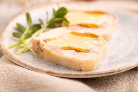 Chicken, egg and dried apricot meatloaf, microgreen on brown concrete background and linen textile.