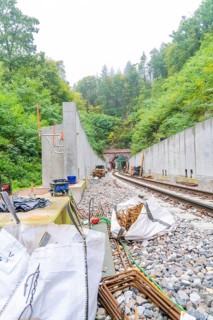 Bauarbeiten an einer Bahnstrecke mitten im Wald mit Betonmauern und Schienen, Bau der Hermann