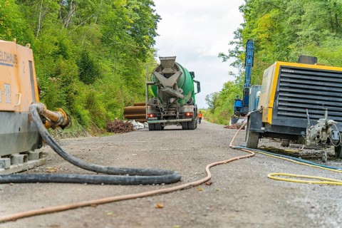 Betonmischfahrzeug und Maschinen auf einer Baustelle im Grünen, Bau der Hermann Hessenahn, Calw,