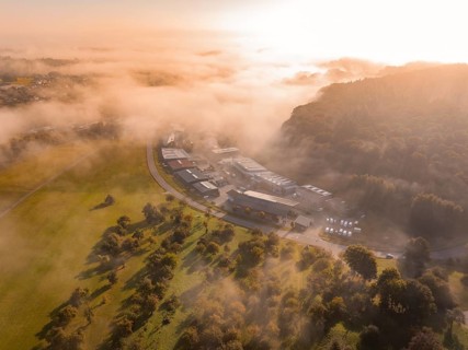 Nebel und Morgensonne schaffen eine atmosphärische Landschaft über Industriegebäuden, Gechingen,