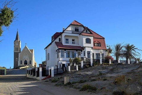 Fachwerkhaus in der Kirchstraße, im Hintergrund die Felsenkirche, Lüderitz, Region Karas, Namibia