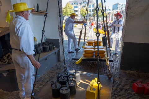 Traditionelle Käsemarktaktivität mit Männern, die Käseräder wiegen, ehemalige Stadtwaage, Käse