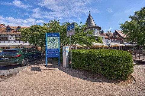 Platz, Parkplatz, Auto, Fachwerkhäuser, Turm, Bäume, Hecke, blauer Himmel, Cumuluswolken,