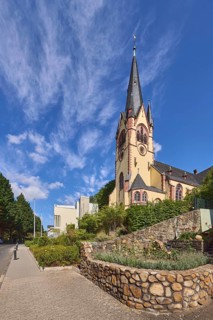 Evangelische Johanneskirche, Kirche, moderne Gebäude, Absperrpoller, Natursteinmauer, Bäume, blauer