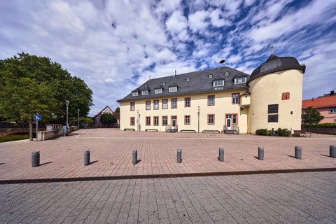 Haus der Vereine, historische Kellerei, Bürgersteig aus Betonpflastersteinen, Absperrpoller, Bäume,