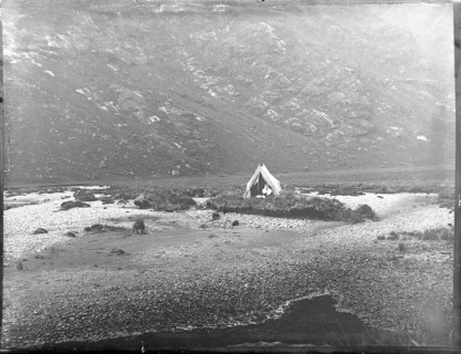 Tent camp on island in river of mountain valley, thought to be Cuillin mountains, Skye, Scotland,