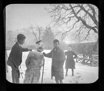 Magic lantern slide c 1900-1910 of children making a snowman in garden