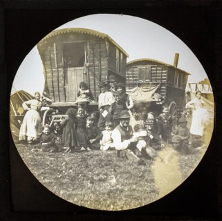 Magic lantern slide portrait of fairground travelling gypsy extended family and caravans, UK circa
