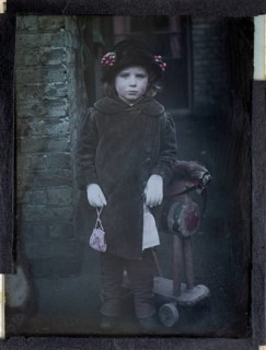 Paget process colourised magic lantern slide portrait of a young girl dressed up in adult clothing,