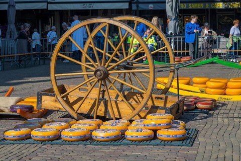 Wooden wagon with large wheels on a market square in the sunshine, wooden wagon wheel with crate
