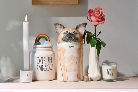 Germany - August 30th 2025: Custom pet dog urn shaped like a French Bulldog surrounded by candle