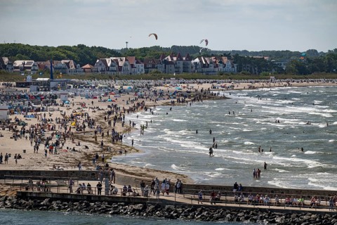 Holidaymakers on the beach and bathing in the sea, kite surfers in the surf, Warnemünde, Rostock,