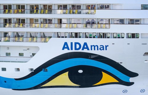 Close-up of an AIDA cruise ship with balconies and striking blue and yellow livery, Warnemünde,