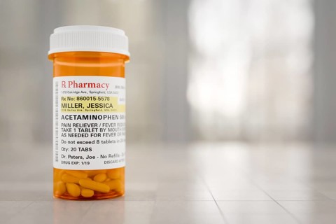 Acetaminophen prescription medicine bottle resting on A bathroom countertop. the label is