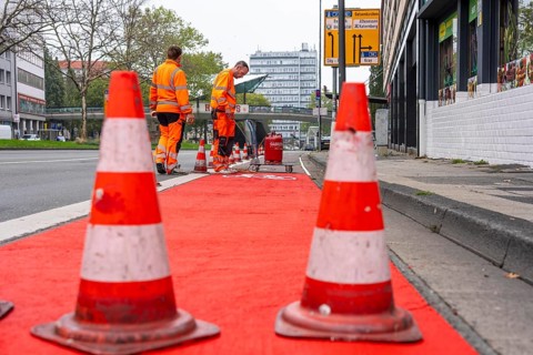 Application of red road surfacing on a cycle lane, inner-city road, so-called cold plastic