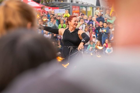 Energetic demonstration with fire wheels in front of an excited audience and curious children,