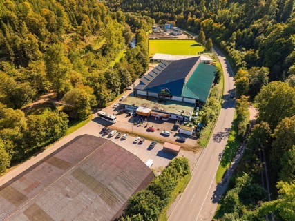 Industrial building complex near a road in the countryside, large car park, sunny atmosphere,