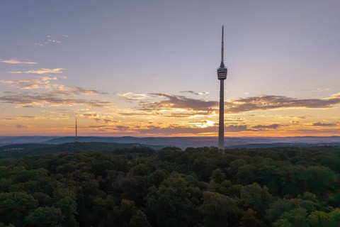 Sunrise behind a television tower in the forest with clouds in the sky, Stuttgart-Degerloch,