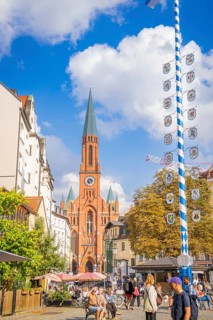 A lively city centre with a high church tower and a maypole, Munich, Germany