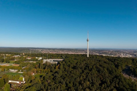 Impressive view over a green forest landscape with a striking television tower and a city in the