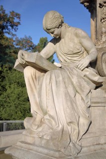 Seated white female figure reading a thick book as a symbol of science, allegory, knowledge,