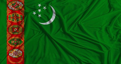 Turkmen flag with fabric texture background. National flag of Turkmenistan with cloth texture