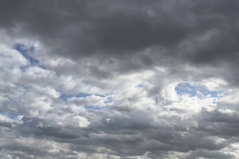 Large field of stratocumulus clouds, in the background altocumulus clouds under blue sky,
