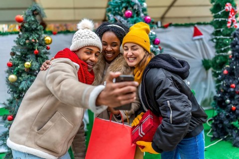 Happy multi ethnic friends enjoying a festive moment while taking a selfie after a day of christmas
