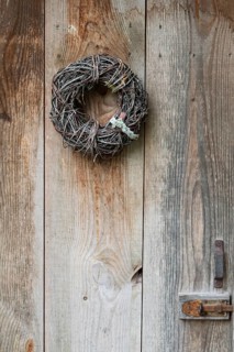 Door wreath made of natural materials in front of an old wooden door, North Rhine-Westphalia,