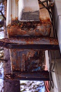 An old and rusty air conditioner hanging on the hotel building, in the sunny outdoor, seaside