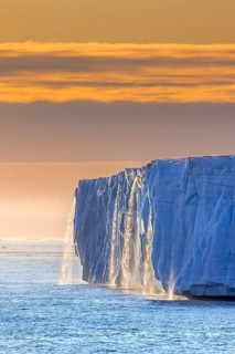 Waterfall at edge of Brasvellbreen glacier from the ice cap Austfonna pouring into the Barents Sea