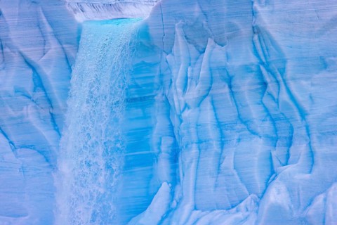 Waterfall at edge of the Brasvellbreen glacier from the ice cap Austfonna pouring into the Barents