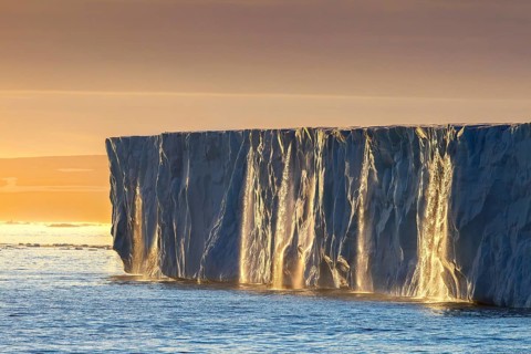 Waterfalls at edge of the Brasvellbreen glacier from ice cap Austfonna debouching into Barents Sea