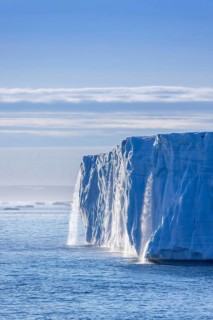 Waterfall at edge of Brasvellbreen glacier from the ice cap Austfonna pouring fresh water into the
