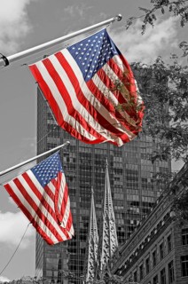 Waving USA flags, behind towers of St Patrick's Cathedral, Manhattan, New York City, USA
