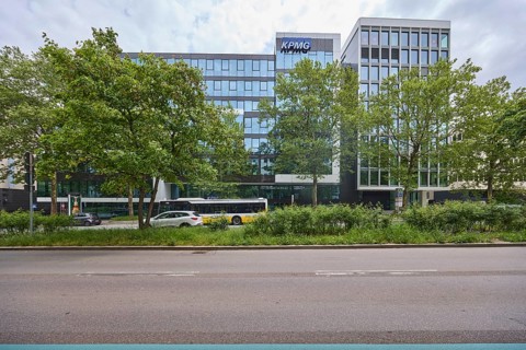 Auditing and management consultancy KPMG, modern architecture, street, public bus, trees, milky