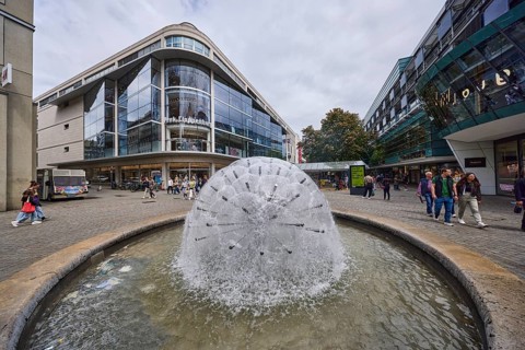 Dandelion fountain, stainless steel fountain, building, pedestrian zone, retail shops, shop window,
