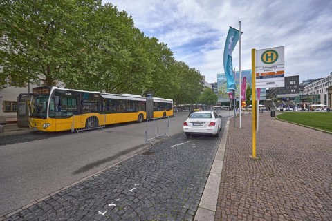 City centre, bus stop Schlossplatz, street, pavement made of cobblestones, public bus, taxi,