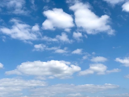 Different types of white cumulus clouds under blue sky above Cirrocumulus clouds below Altocumulus